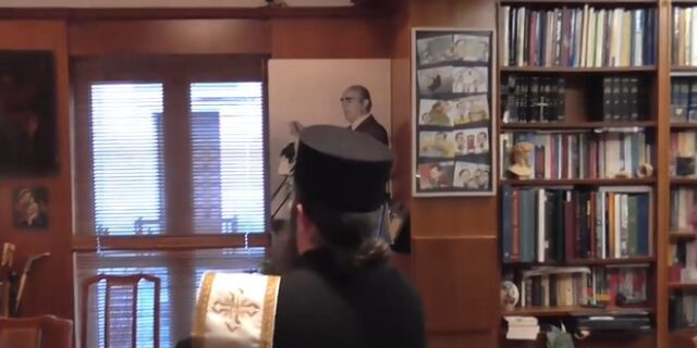 Ιερέας αγιάζει το πορτρέτο του Κ. Καραμανλή στο γραφείο του Νικολόπουλου