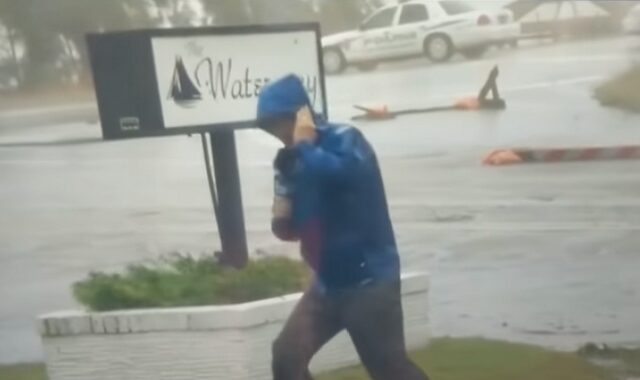 Ρεπόρτερ μάχεται με τον τυφώνα Φλόρενς ενώ πίσω του άλλοι περπατούν χαλαροί