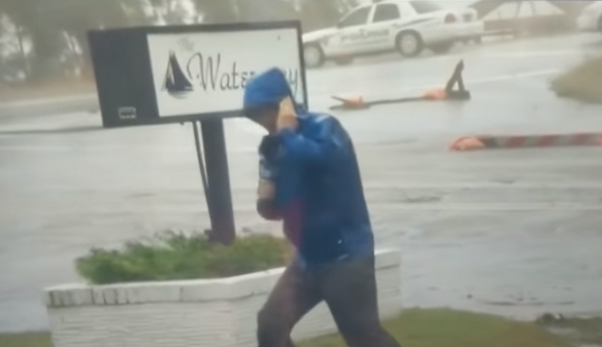 Ρεπόρτερ μάχεται με τον τυφώνα Φλόρενς ενώ πίσω του άλλοι περπατούν χαλαροί