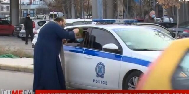 Θεσσαλονίκη: Ιερέας χωρίς μάσκα ραντίζει με αγιασμό αστυνομικούς και δίνει να φιλήσουν σταυρό