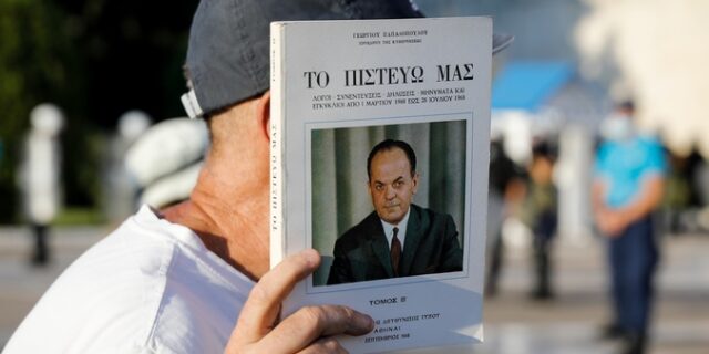 Διαδηλωτής κατά των εμβολίων με το βιβλίο του δικτάτορα Παπαδόπουλου στα χέρια