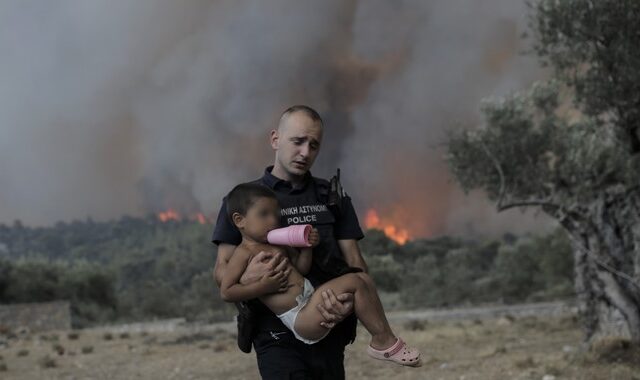 Φωτιά στα Δερβενοχώρια: Αστυνομικός παίρνει παιδί αγκαλιά για να το σώσει από τις φλόγες