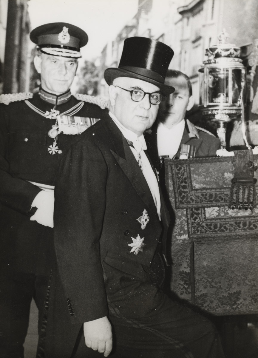 Λονδίνο, 6 Ιουνίου 1957. Ο Γιώργος Σεφέρης μεταβαίνει από την πρεσβευτική κατοικία στοπαλάτι του Μπάκινχαμ με την παραδοσιακή άμαξα, όπου θα επιδώσει τα διαπιστευτήρια του στην Βασίλισσα Ελισάβετ. Η φωτογραφία αυτή διανεμήθηκε από το Γαλλικό Πρακτορείο Ειδήσεων την ημέρα της αναγγελίας του Νόμπελ Λογοτεχνίας στον Σεφέρη