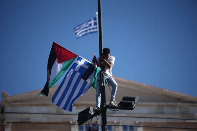 Η στιγμή που ο Παλαιστίνιος ανεβάζει την παλαιστινιακή σημαία μαζί με την ελληνική, στο Σύνταγμα