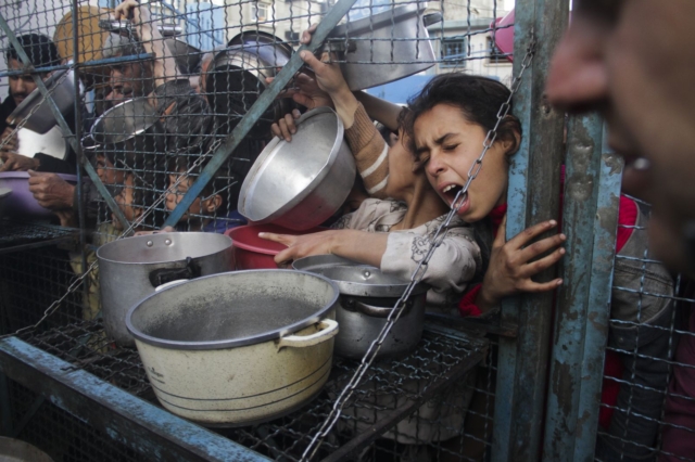Παλαιστίνιοι σχηματίζουν ουρά για να λάβουν δωρεάν γεύματα στον προσφυγικό καταυλισμό της Τζαμπαλίγια στη Λωρίδα της Γάζας