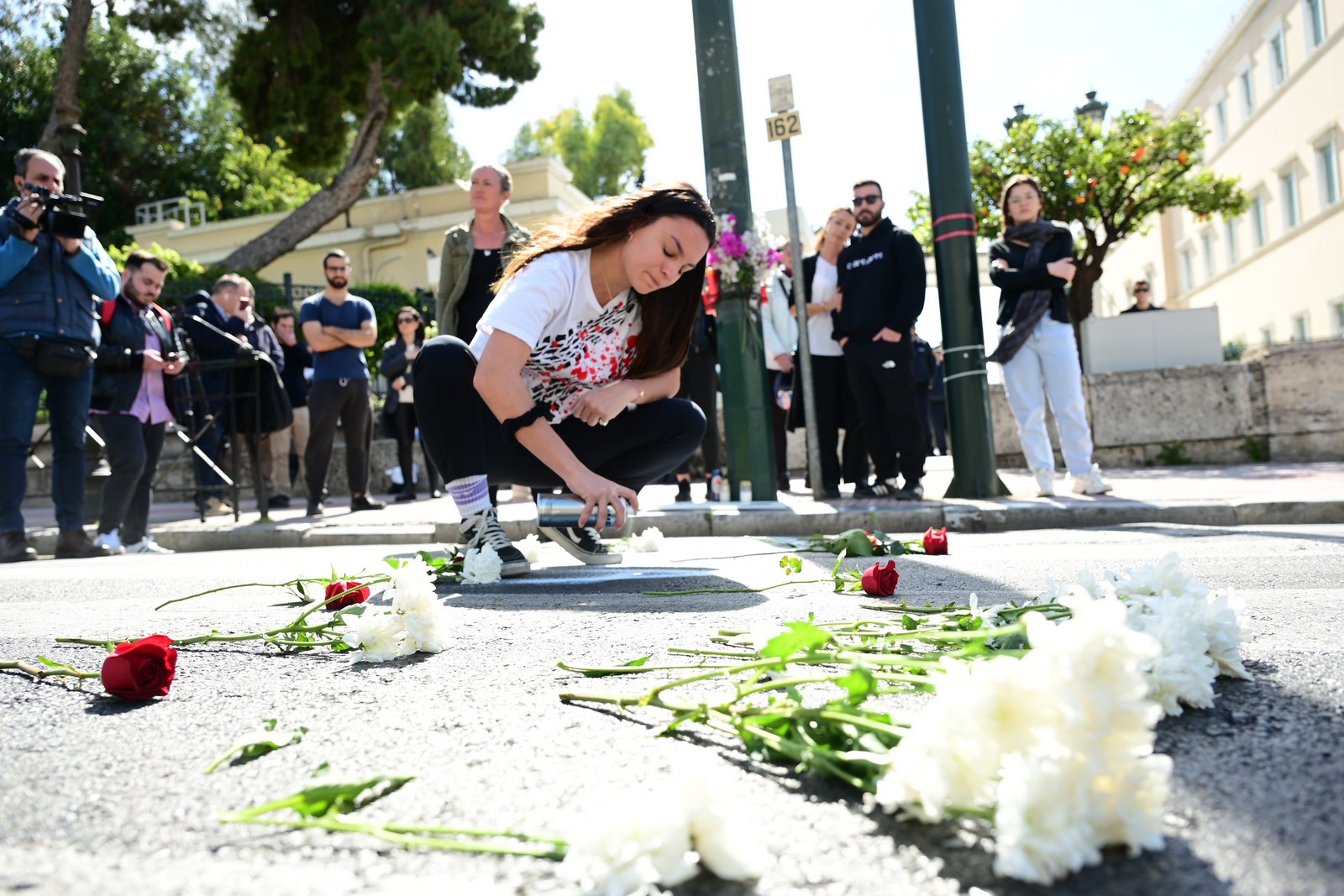 Η οικογένεια και φίλοι του Ιάσονα Λαλαούνη, στο σημείο έξω από την Βουλή όπου σκοτώθηκε πριν από τρία χρόνια σε τροχαίο δυστύχημα στο οποίο ενεπλάκη ο οδηγός του υπηρεσιακού οχήματος της Ντόρας Μπακογιάννη, Τρίτη 12 Μαρτίου 2024