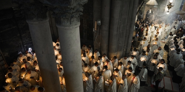 Καθολικοί κληρικοί κρατούν κεριά καθώς περπατούν κατά τη διάρκεια της πομπής του πλυσίματος των ποδιών στην εκκλησία του Παναγίου Τάφου, όπου πολλοί χριστιανοί πιστεύουν ότι ο Ιησούς σταυρώθηκε, θάφτηκε και αναστήθηκε, στην Παλιά Πόλη της Ιερουσαλήμ