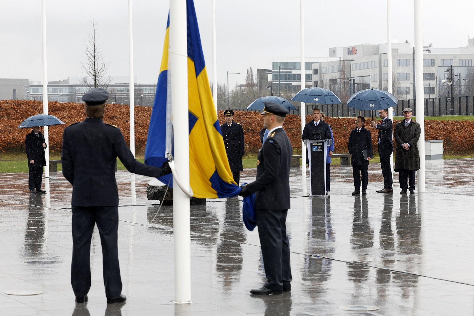 Δύο στρατιωτικοί ετοιμάζονται να υψώσουν τη σουηδική σημαία κατά τη διάρκεια της τελετής για την ένταξη της Σουηδίας στο ΝΑΤΟ