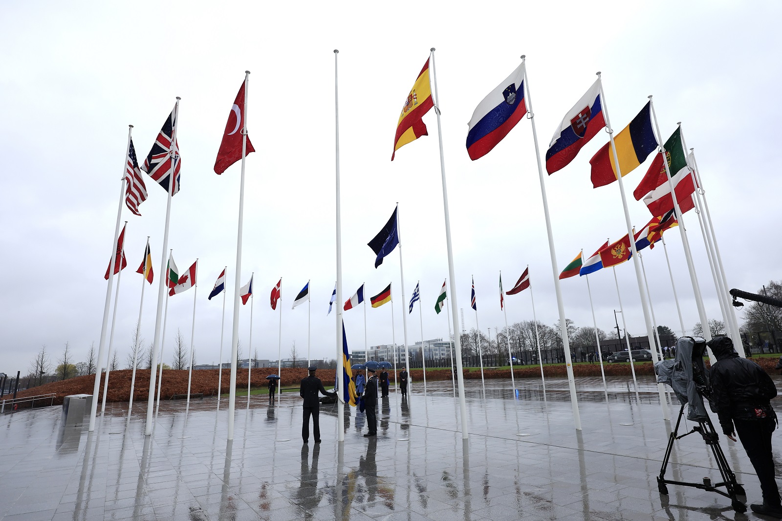 Δύο στρατιωτικοί ετοιμάζονται να υψώσουν τη σουηδική σημαία κατά τη διάρκεια της τελετής για την ένταξη της Σουηδίας στο ΝΑΤΟ