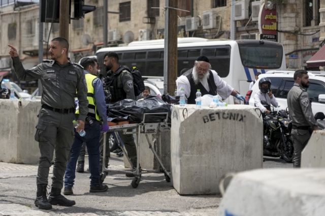 Ισραηλινοί μεταφέρουν τη σορό ενός άνδρα που έπεσε νεκρός από πυροβολισμούς μετά τον τραυματισμό αστυνομικού με μαχαίρι