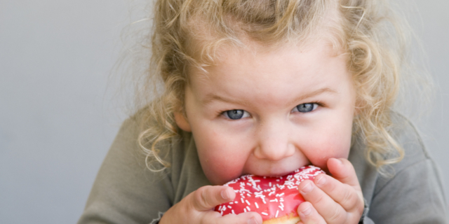Παιδί 3 ετών τρώει ντόνατ με γλάσο ζάχαρης