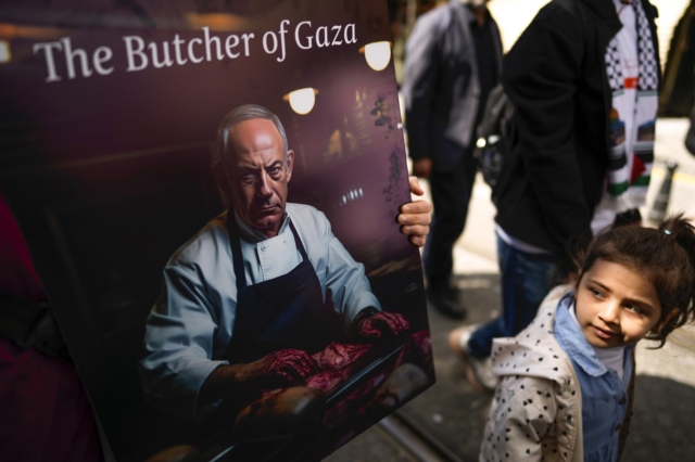 Ένα κορίτσι κοιτάζει μια αφίσα του Ισραηλινού πρωθυπουργού Βενιαμίν Νετανιάχου κατά τη διάρκεια μιας διαδήλωσης υπέρ των Παλαιστινίων
