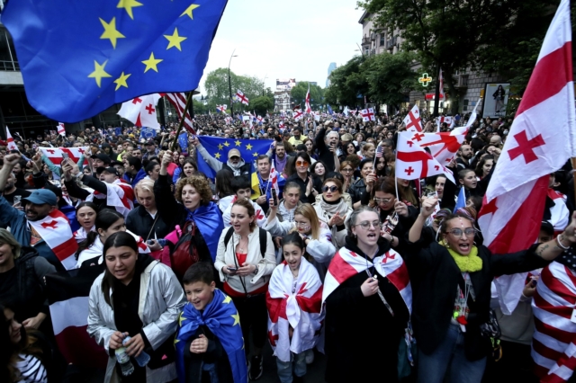 Διαδηλωτές με σημαίες της Γεωργίας και της ΕΕ κατά τη διάρκεια διαμαρτυρίας κατά του νομοσχεδίου "ξένης επιρροής την Ημέρα της Ανεξαρτησίας στο κέντρο της Τιφλίδας της Γεωργίας, Κυριακή, 26 Μαΐου 2024.