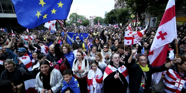 Διαδηλωτές με σημαίες της Γεωργίας και της ΕΕ κατά τη διάρκεια διαμαρτυρίας κατά του νομοσχεδίου "ξένης επιρροής την Ημέρα της Ανεξαρτησίας στο κέντρο της Τιφλίδας της Γεωργίας, Κυριακή, 26 Μαΐου 2024.