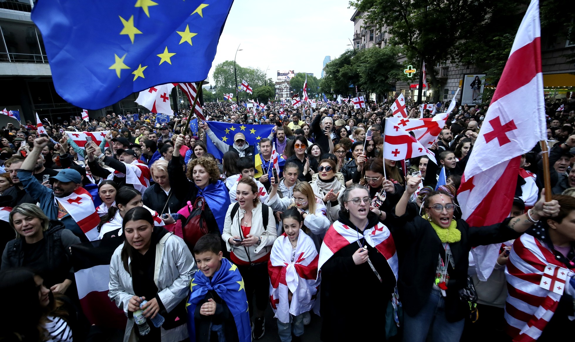 Διαδηλωτές με σημαίες της Γεωργίας και της ΕΕ κατά τη διάρκεια διαμαρτυρίας κατά του νομοσχεδίου "ξένης επιρροής" την Ημέρα της Ανεξαρτησίας στο κέντρο της Τιφλίδας της Γεωργίας, Κυριακή, 26 Μαΐου 2024.
