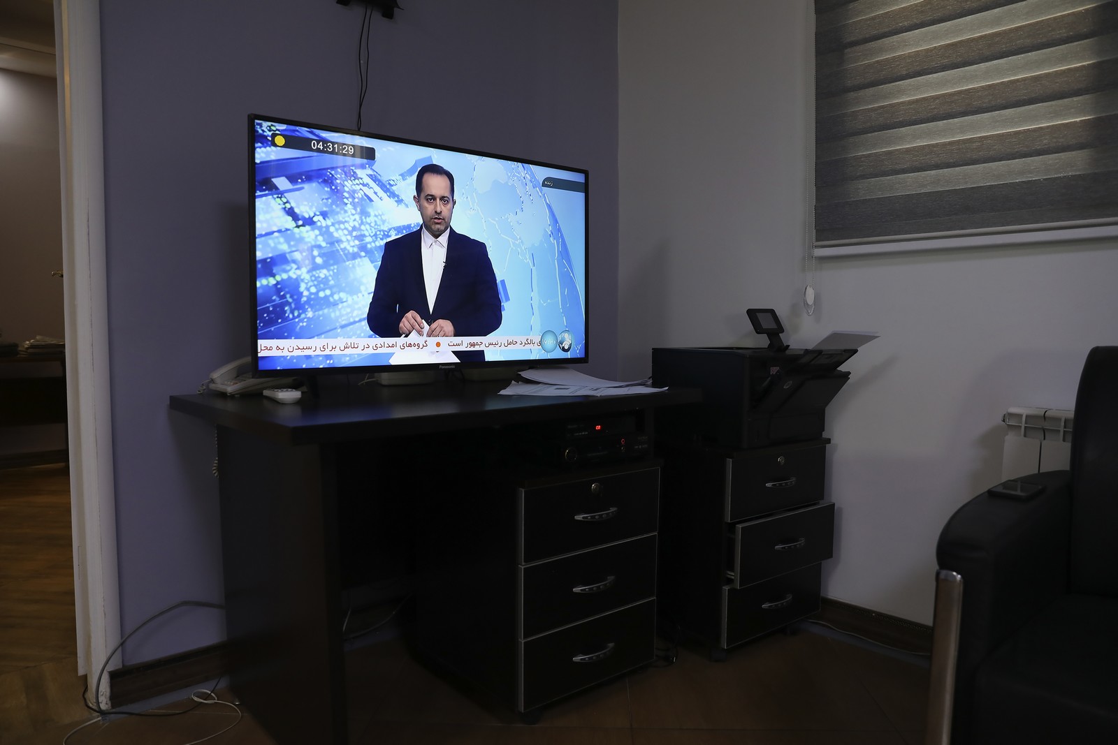 Ένας παρουσιαστής; ειδήσεων εκφωνεί την είδηση του ατυχήματος του Ιρανού προέδρου 