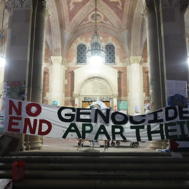 Διαδηλωτές στο πανεπιστήμιο της Καλιφόρνια κρατούν πανό που χαρακτηρίζει ως γενοκτονία τον πόλεμο στη Γάζα