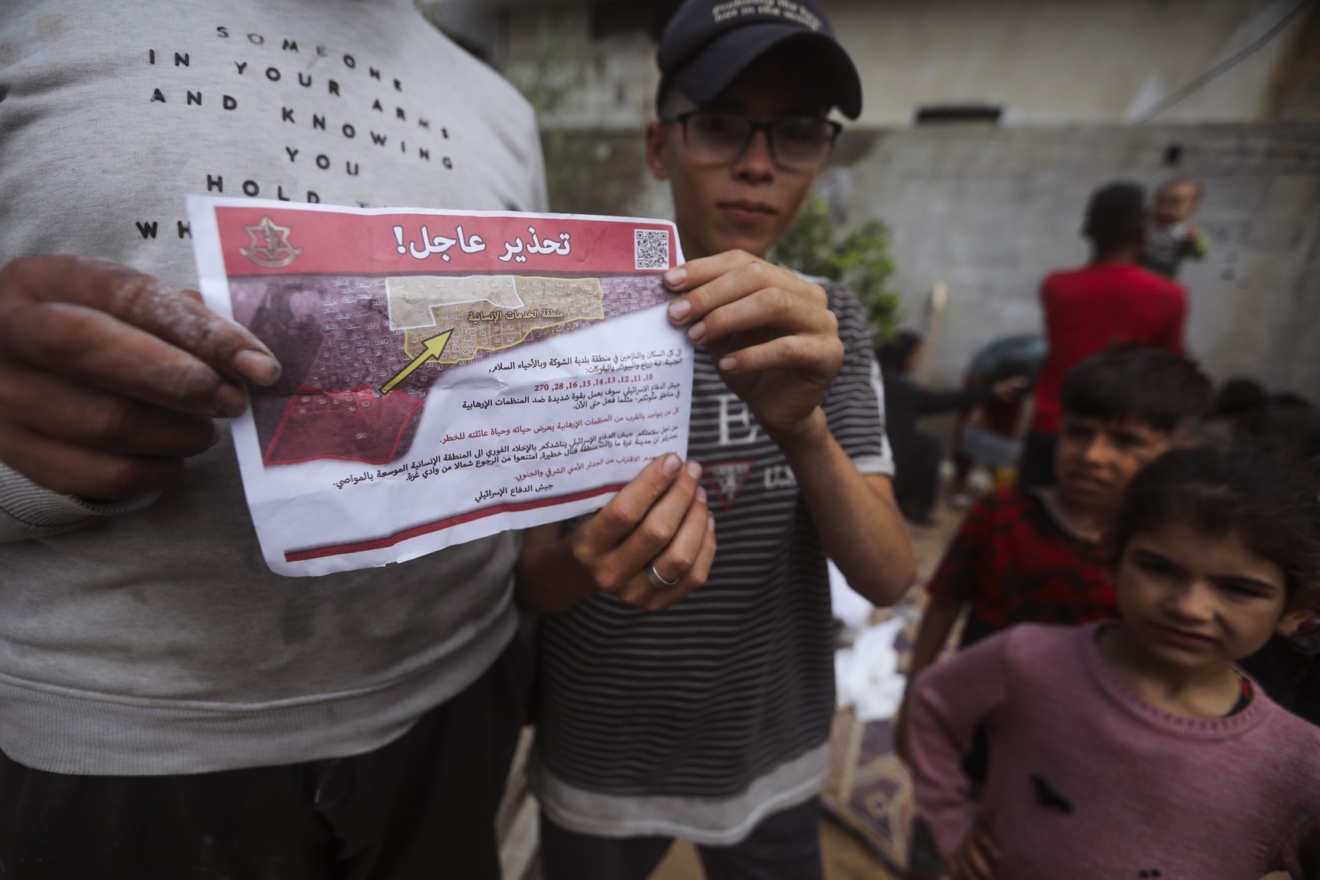 Παλαιστίνιοι στη Ράφα κρατούν το φυλλάδιο που πετούν οι Ισραηλινές δυνάμεις