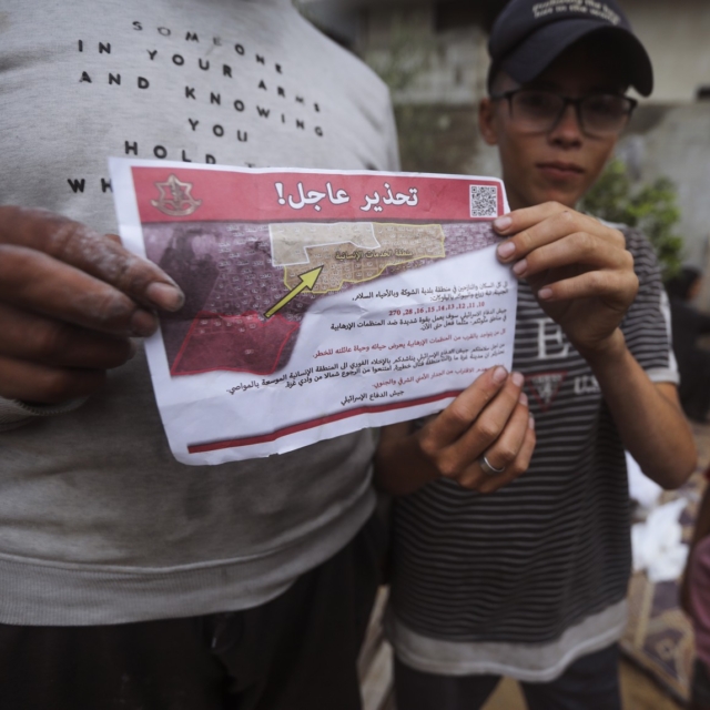 Παλαιστίνιοι στη Ράφα κρατούν το φυλλάδιο που πετούν οι Ισραηλινές δυνάμεις