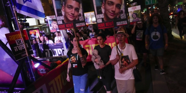 Συγγενείς και φίλοι ομήρων που κρατούνται στη Λωρίδα της Γάζας με τις φωτογραφίες τους κατά τη διάρκεια συλλαλητηρίου