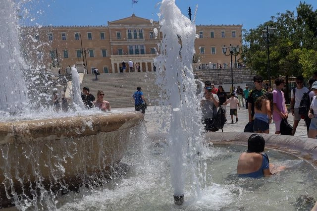 Πολίτες μπαίνουν μέσα στο σιντριβάνι της Πλατείας Συντάγματος για να δροσιστούν