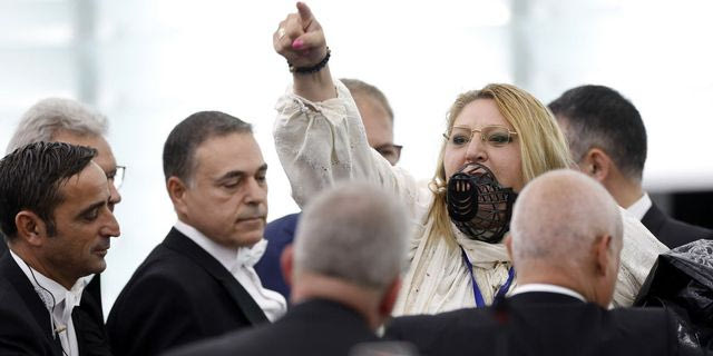 Η Ντιάνα Σοσοάκα με φίμωτρο στο πρόσωπo κατά τη διάρκεια συζήτησης στην ολομέλεια του Ευρωπαϊκού Κοινοβουλίου