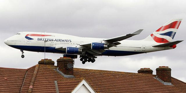 Αεροπλάνο της British Airways πετάει πάνω από στέγες καθώς προσγειώνεται στο αεροδρόμιο Χίθροου του Λονδίνου