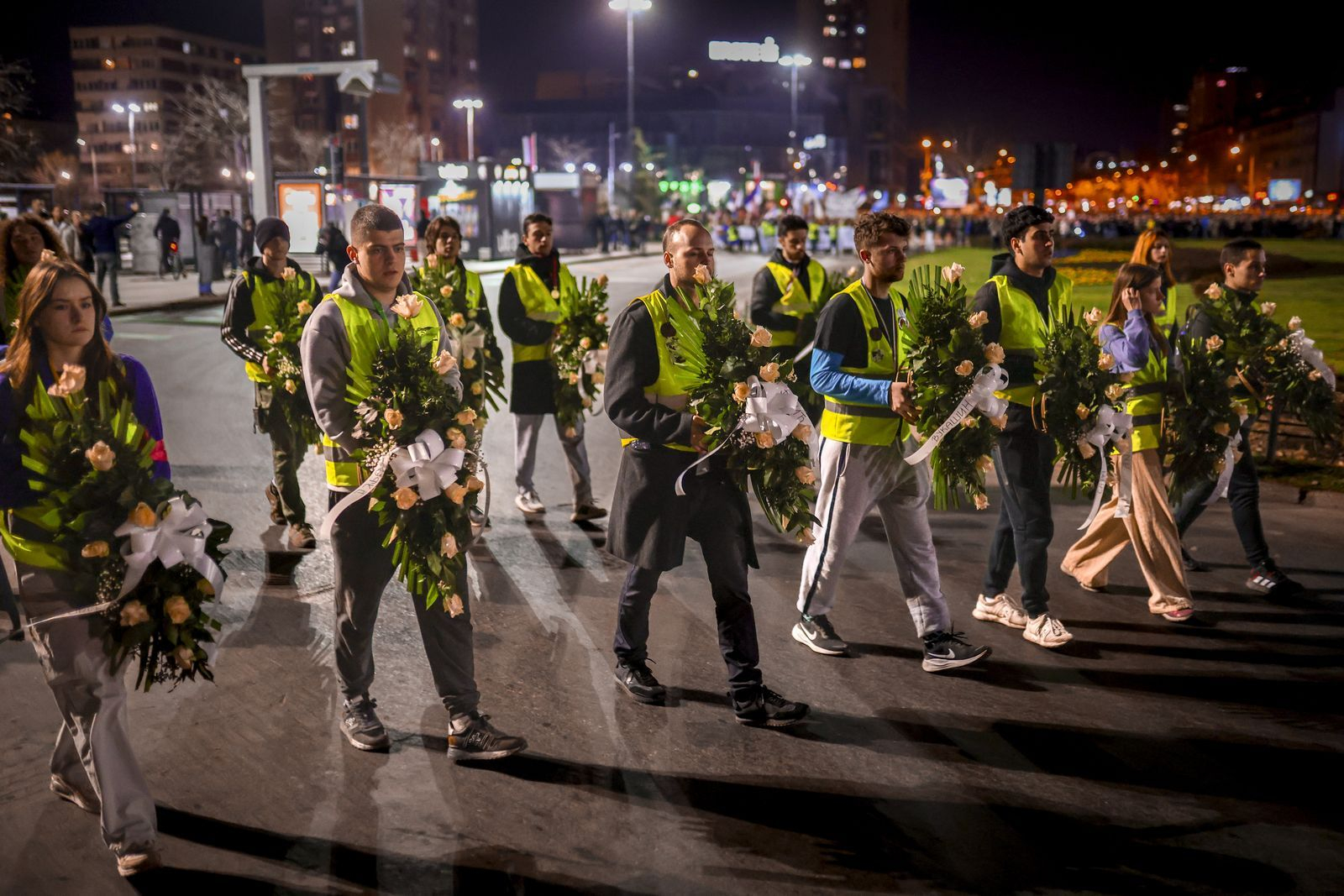 Νέοι μεταφέρουν στεφάνια με τα ονόματα των θυμάτων κατά τη διάρκεια διαμαρτυρίας στο Νόβι Σαντ της Σερβίας