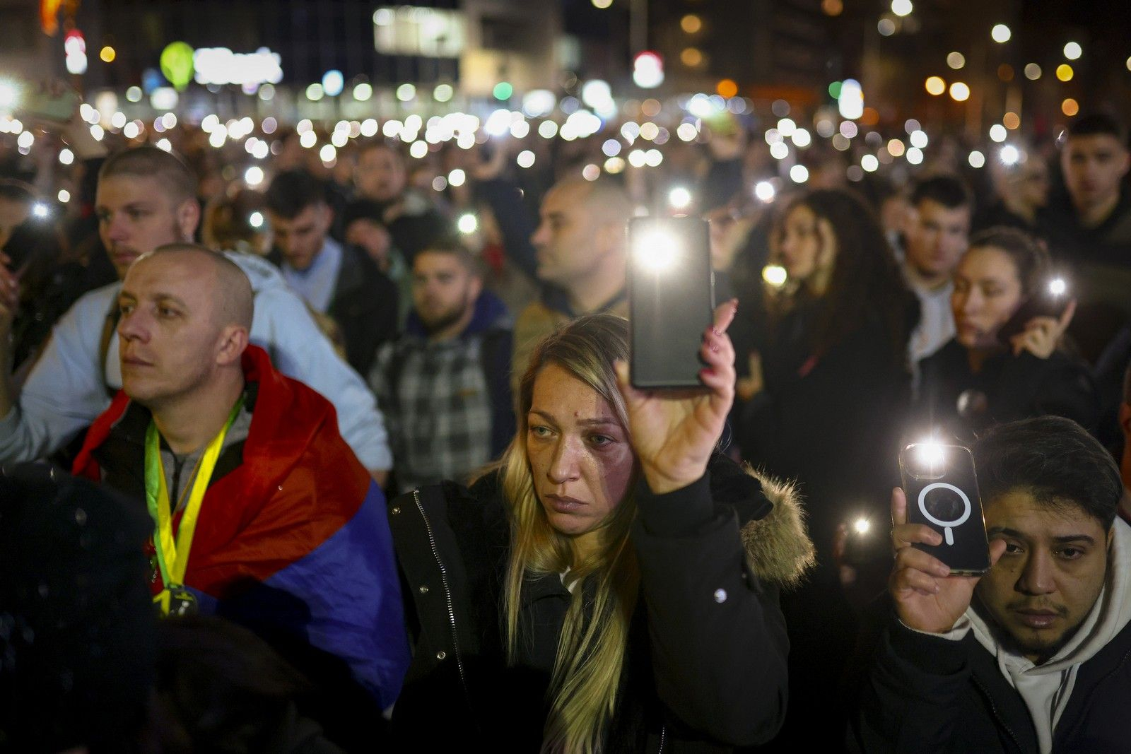 Διαδηλωτές κρατούν τα κινητά τους τηλέφωνα με αναμμένους φακούς κατά τη διάρκεια διαμαρτυρίας στο Νόβι Σαντ