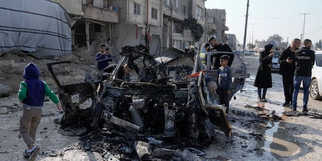 Μικροί και μεγάλοι στη Δυτική Όχθη, γύρω από ενα κατεστραμμένο αυτοκίνητο