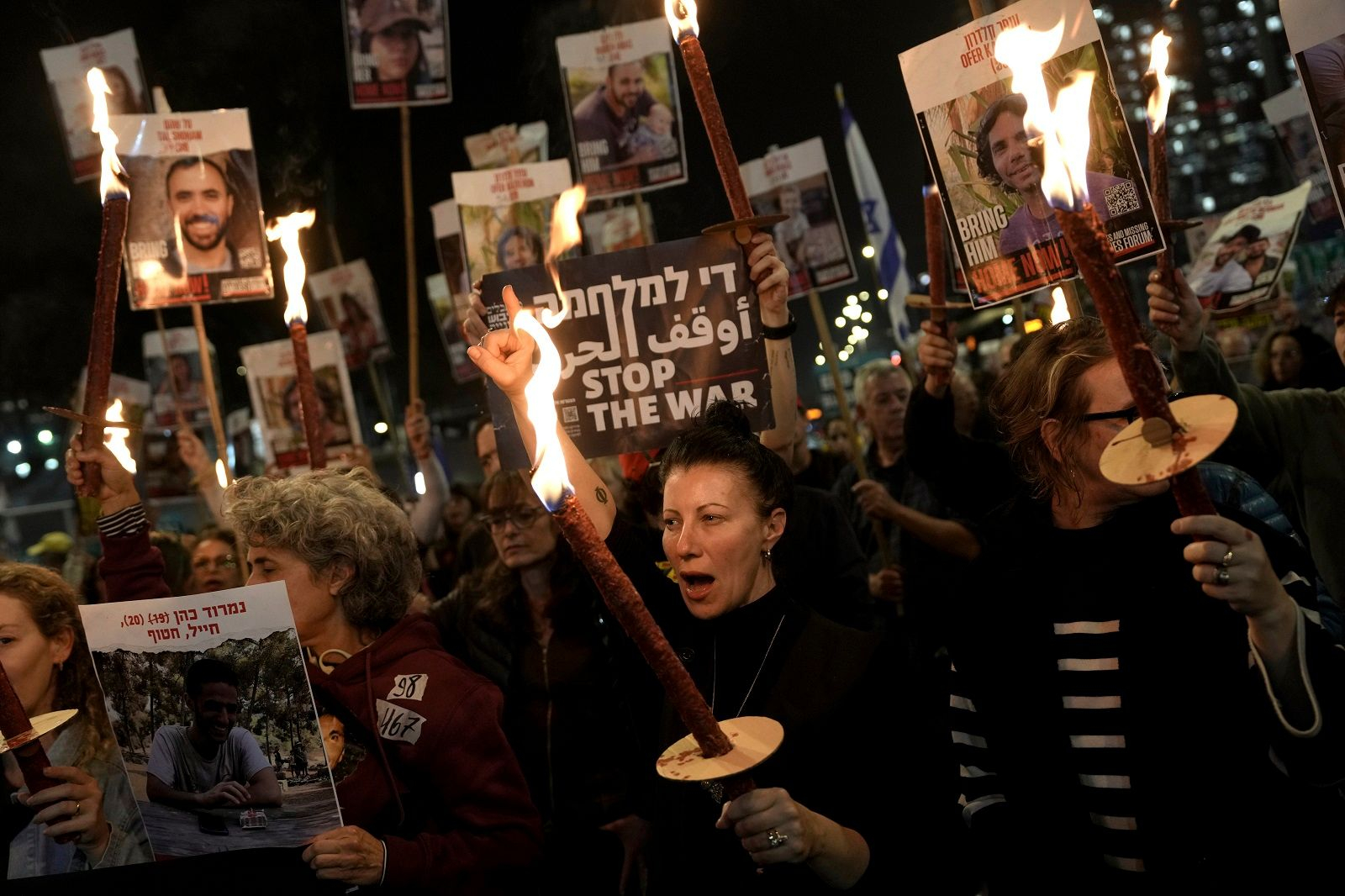 a group of people holding torches and signs