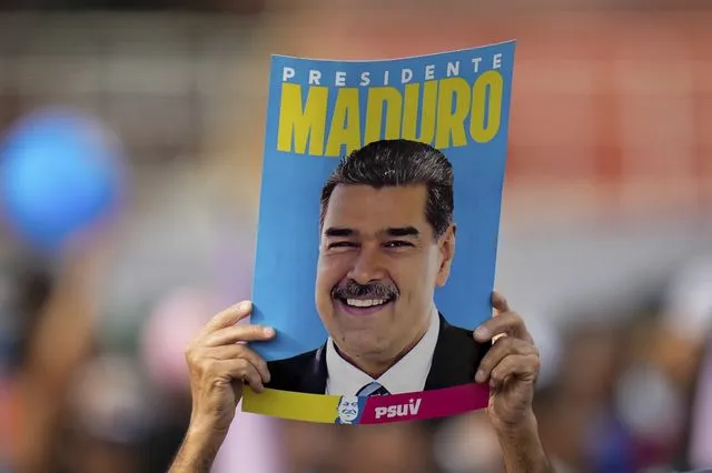 Υποστηρικτής του Μαδούρο κρατά αφίσα του στα χέρια σε διαδήλωση στο Καράκας