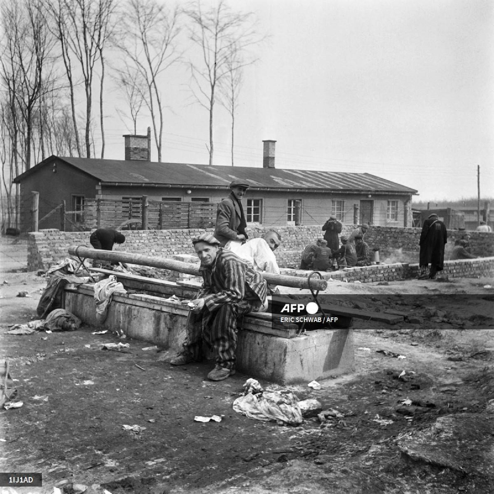 Επιζώντες του ναζιστικού στρατοπέδου συγκέντρωσης Μπούχενβαλντ κάθονται σε αποχωρητήριο τον Απρίλιο του 1945, μετά την απελευθέρωση του στρατοπέδου από τα συμμαχικά στρατεύματα. 