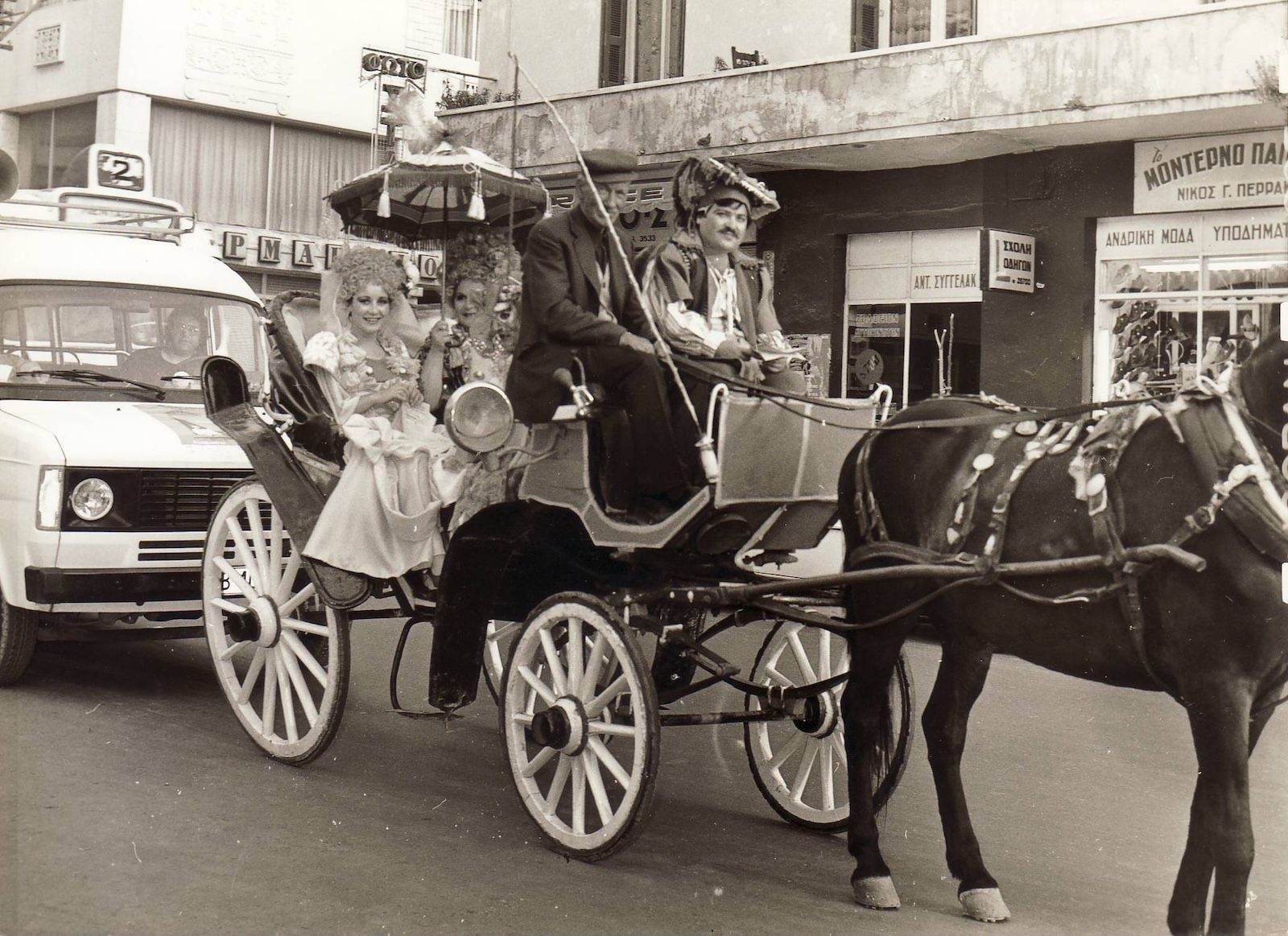 Οι ηθοποιοί Χρήστος Βαλβανίδης, Μαρία Ζαχαρία, Μπέτυ Βαλάση και Λευτέρης Τζουλάκης (μέσα στο λεωφορειάκι) διαφημίζουν στους δρόμους της πόλης τη θεατρική παραγωγή του Ημικρατικού Θεάτρου Κρήτης − Εταιρείας Θεάτρου Κρήτης «Ο Κατζούρμπος», σε σκηνοθεσία Κωστή Μιχαηλίδη και ενδυματολογικό σχεδιασμό του Γιάννη Κύρου, το καλοκαίρι του 1980. 