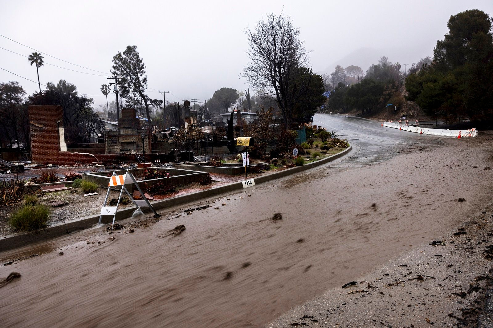Λάσπη ρέει σε δρόμο στη ζώνη της πυρκαγιάς Eaton κατά τη διάρκεια καταιγίδας την Πέμπτη 13 Φεβρουαρίου, στην Altadena της Καλιφόρνια.