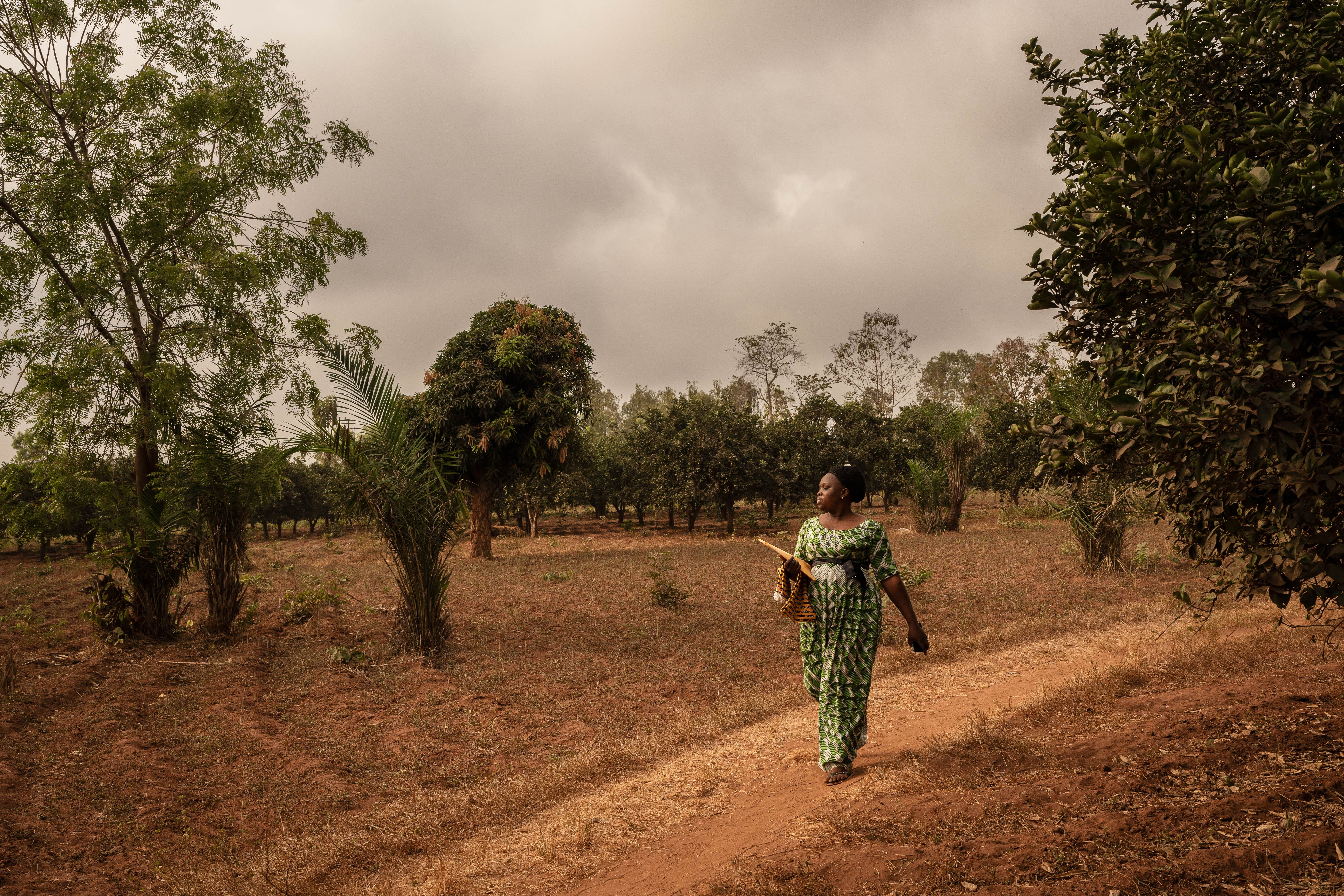 Η Lucienne, μία από τις γυναίκες ηγέτες που εκπαιδεύτηκαν από τους Γιατρούς Χωρίς Σύνορα, περπατά προς το χωριό της, Agbodonhouin, για να πραγματοποιήσει εκπαιδευτική συνεδρία σχετικά με την προγεννητική φροντίδα.
