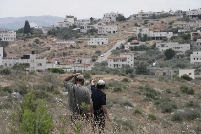 Ισραηλινοί έποικοι έξω από χωριό της κατεχόμενης Δυτικής Όχθης