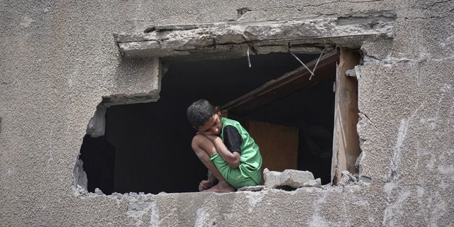 Ένα αγόρι στέκεται στα χαλάσματα ενός κτιρίου, μετά από βομβαρδισμό του Ισραήλ στη Γάζα