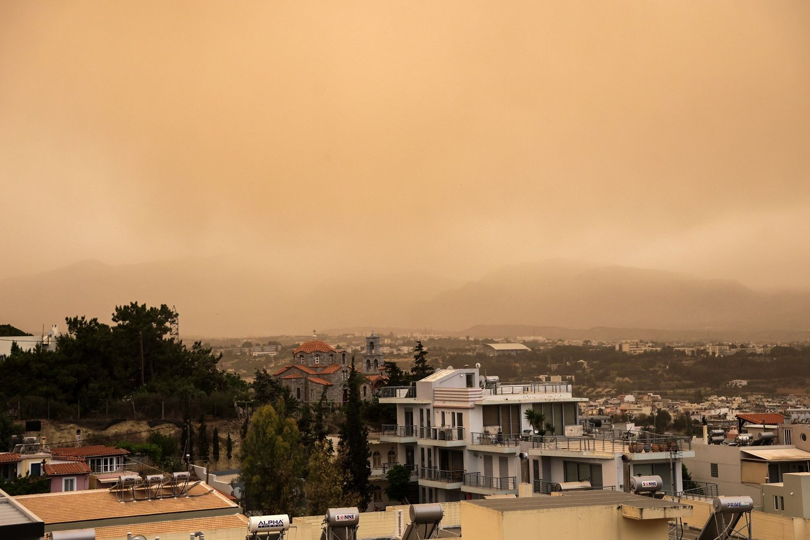 Στιγμιότυπο από το Ηράκλειο Κρήτης το απόγευμα της Κυριακής 25 Μαΐου 2025. Σκόνη από την Αφρική κάλυψε την πόλη. Για δεύτερη συνεχόμενη ημέρα το νησί πλήττεται από υψηλές συγκεντρώσεις αφρικανικής σκόνης σε συνδυασμό με έντονους νοτιάδες, δημιουργώντας μια ιδιαίτερα αποπνικτική ατμόσφαιρα σε πολλές περιοχές.
