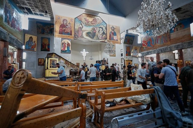 Σύροι πολίτες και δυνάμεις ασφαλείας επιθεωρούν τις ζημιές μέσα στην εκκλησία του Αγίου Ηλία, όπου βομβιστής αυτοκτονίας ανατινάχθηκε στην περιοχή Ντουεϊλά, στα περίχωρα της Δαμασκού, στη Συρία, την Κυριακή 22 Ιουνίου 2025.