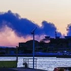 Καπνός από την πυρκαγιά σε εργοστάσιο στα Μέγαρα, όπως διακρίνεται από το λιμάνι του Πειραιά