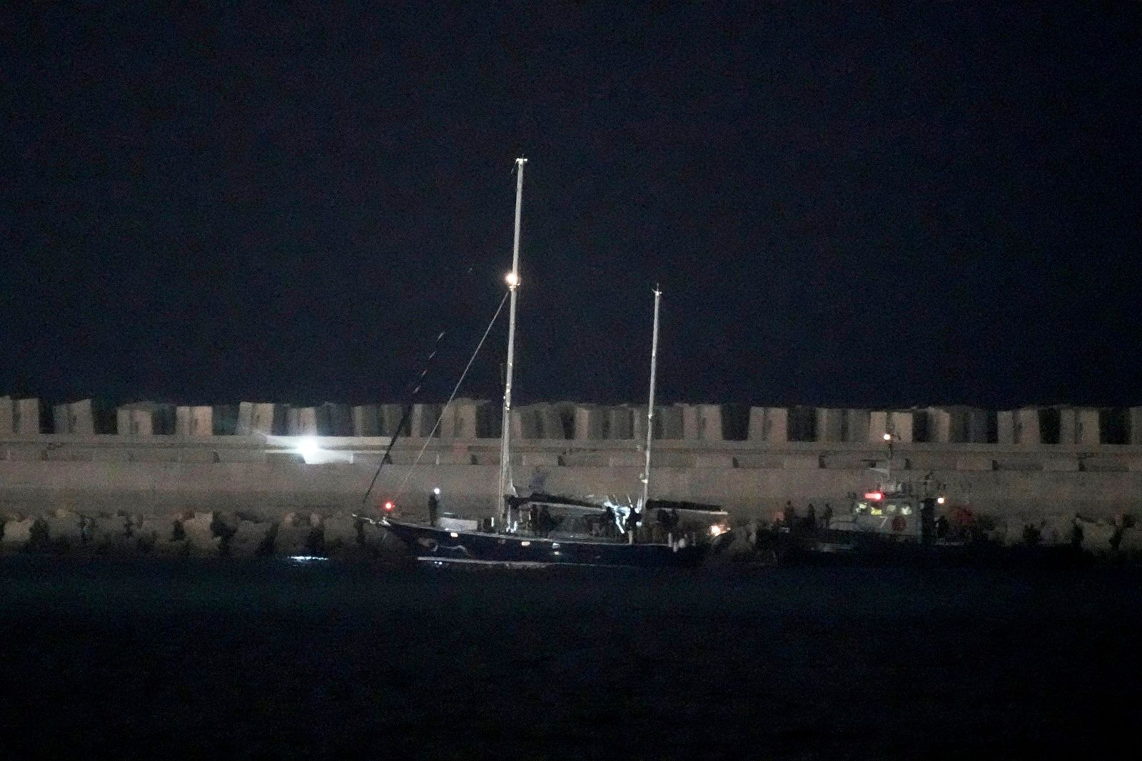 Το πλοίο ανθρωπιστικής βοήθειας με προορισμό τη Γάζα, Madleen (δεξιά), συνοδευόμενο από τις ισραηλινές ναυτικές δυνάμεις, κατευθύνεται προς το λιμάνι του Ασντόν στο νότιο Ισραήλ αφού καταλήφθηκε από τις ισραηλινές δυνάμεις, Δευτέρα, 9 Ιουνίου 2025. (Φωτογραφία: AP / Leo Correa)