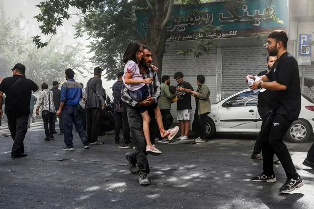 Άνδρας μεταφέρει ένα τραυματισμένο κορίτσι μετά από έκρηξη στο κέντρο της Τεχεράνης