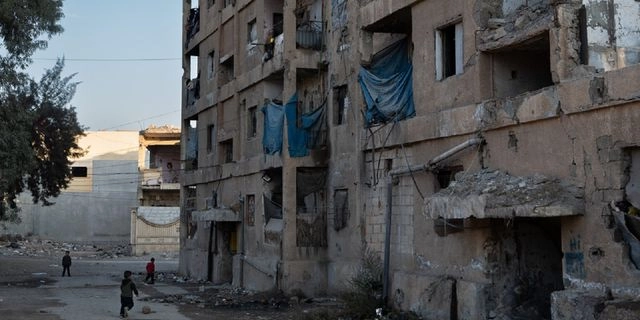 Παιδιά παίζουν έξω από τα ερείπια κτιρίου στη Ράκα.