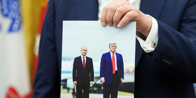 Ο Ντόναλντ Τραμπ κρατά μια φωτογραφία του με τον Βλαντίμιρ Πούτιν μετά την προσγείωσή του στην Αλάσκα