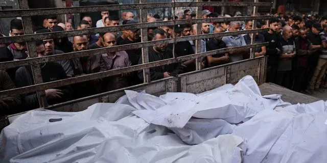 Παλαιστίνιοι αντικρίζουν σορούς, μετά τα τελευταία χρονικά φονικά πλήγματα του Ισραήλ, στη Γάζα