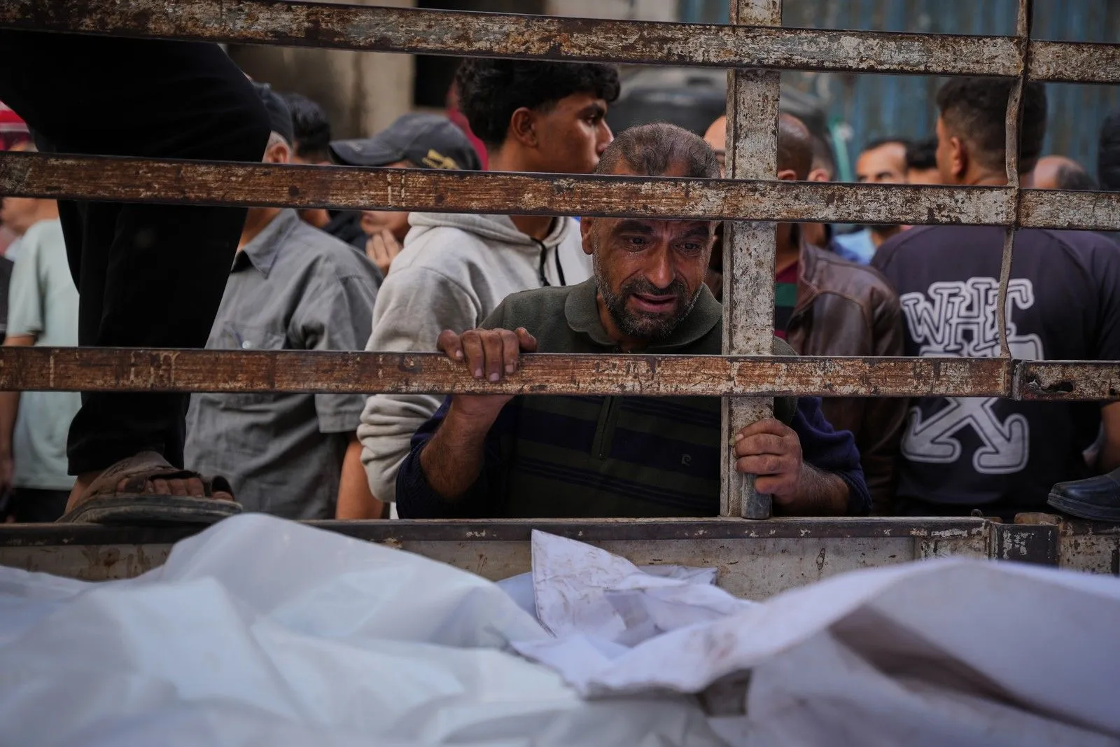 Παλαιστίνιοι αντικρίζουν σορούς, μετά τα τελευταία χρονικά φονικά πλήγματα του Ισραήλ, στη Γάζα