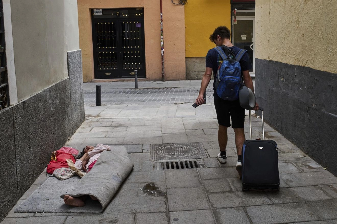 Τουρίστας περπατά δίπλα από άστεγο στη Μαδρίτη