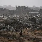 Γυναίκα περπατά ανάμεσα στα συντρίμμια σε βομβαρδισμένη γειτονιά στη Γάζα