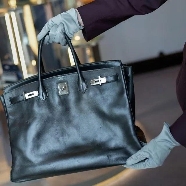 Yπάλληλος δείχνει την τσάντα Birkin που δόθηκε στην Jane Birkin από την Hermès το 2003, κατά τη διάρκεια της εβδομάδας συλλεκτών του Sotheby’s στο Άμπου Ντάμπι, Ηνωμένα Αραβικά Εμιράτα, την Τετάρτη 3 Δεκεμβρίου 2025